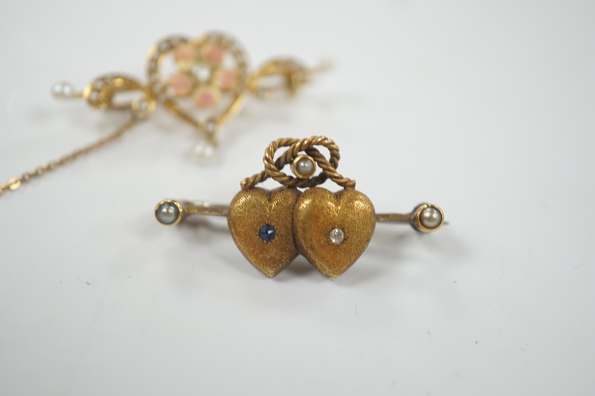 An Edwardian 625 yellow metal, enamel and seed pearl set drop bar brooch, with central heart shaped motif, 40mm, together with a yellow metal and gem set twin hearts bar brooch.